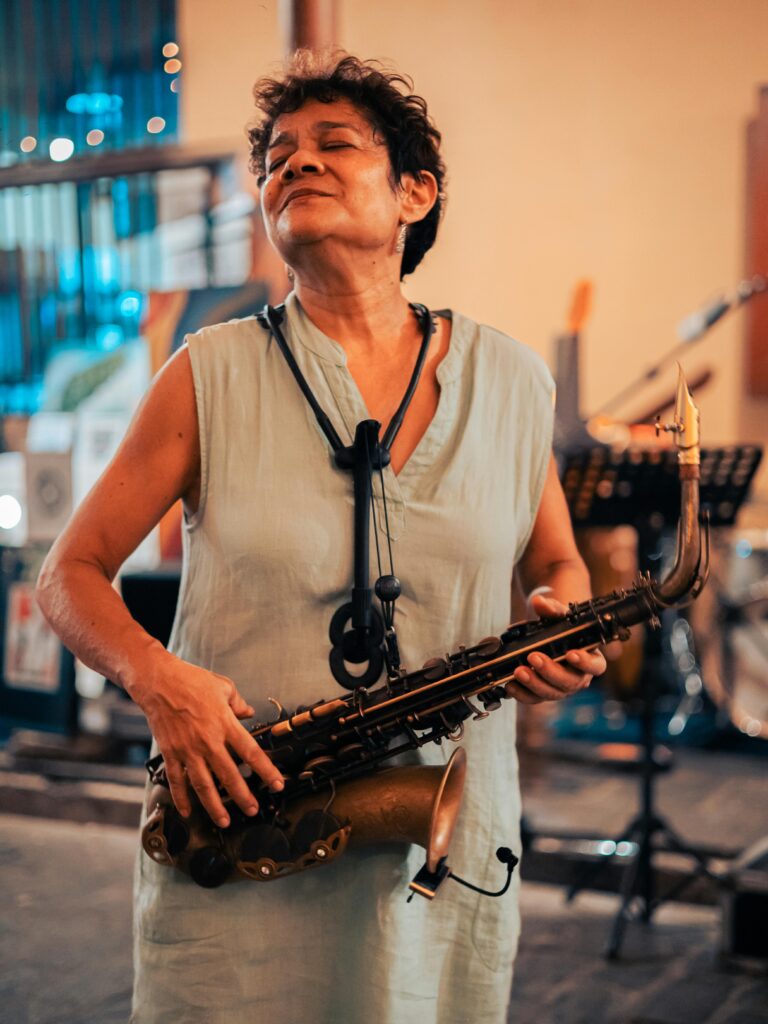 Elderly woman in blissful saxophone performance indoors.